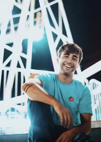 A man in blue shirt smiling for the camera.