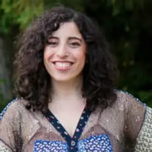 A woman with curly hair smiling for the camera.