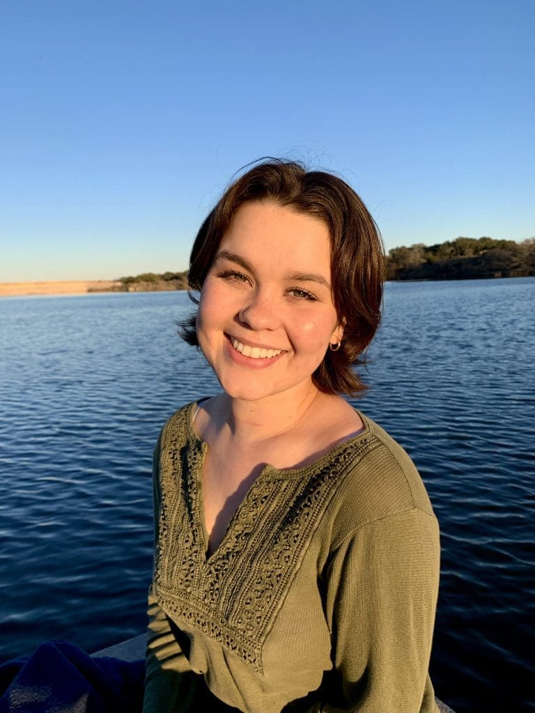 A woman standing in front of the water.