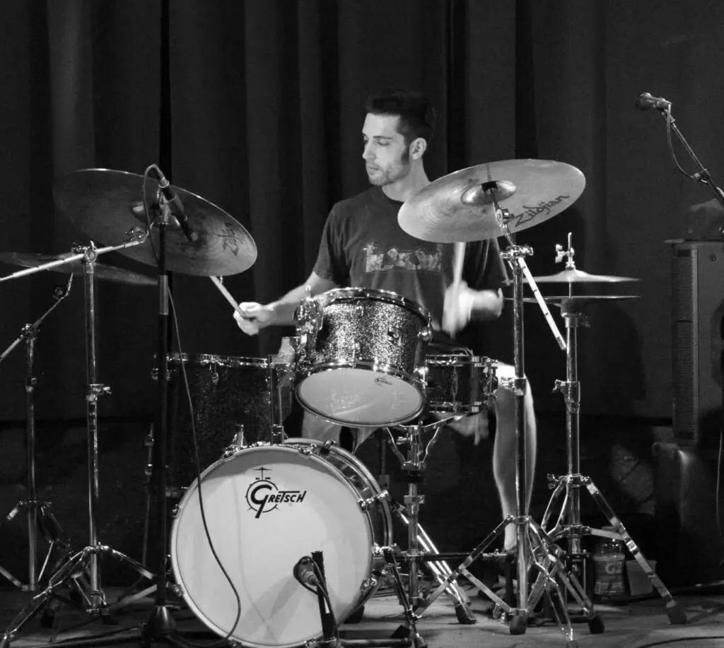 A man playing drums in front of a microphone.