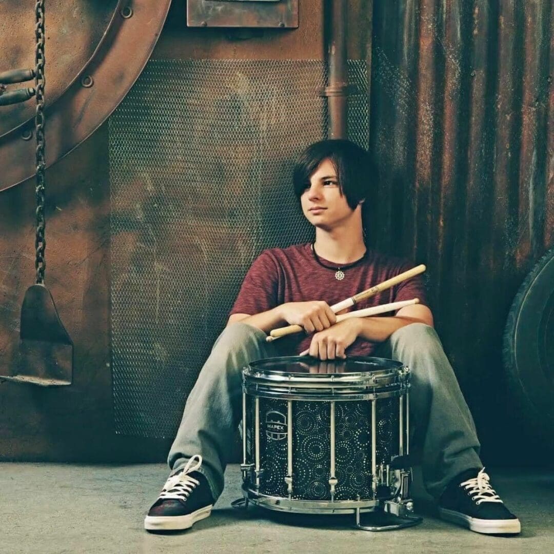 A man sitting on top of a drum.