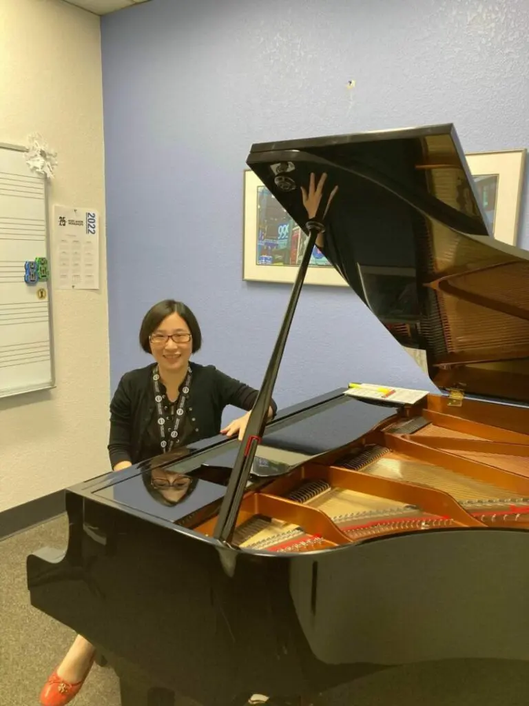 A woman sitting at the piano in an office.