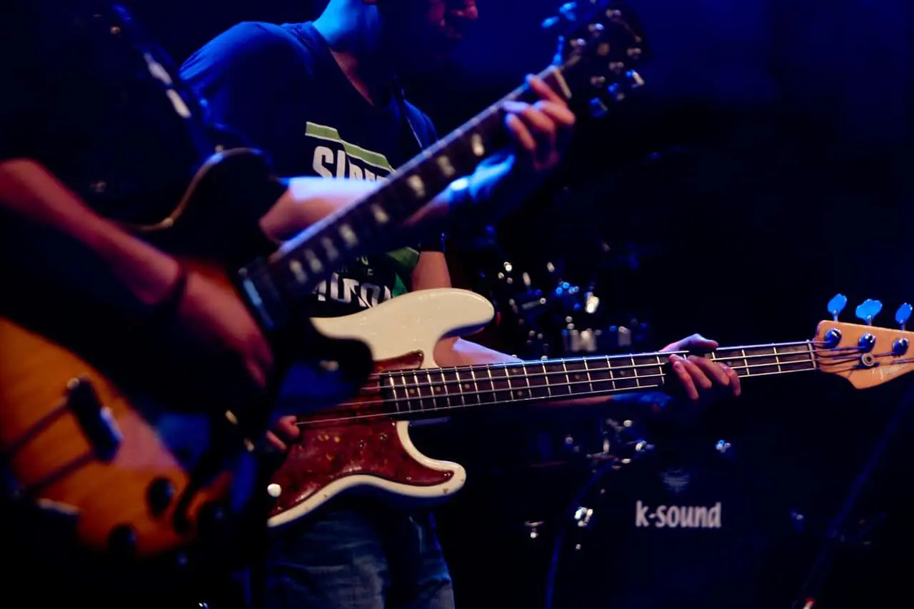 A man playing guitar in front of other people.