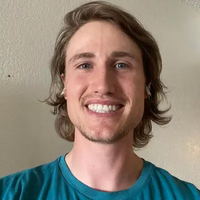 A man with long hair and a blue shirt.