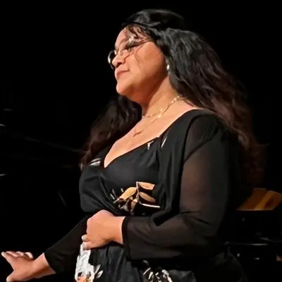 A woman in black dress holding a white object.