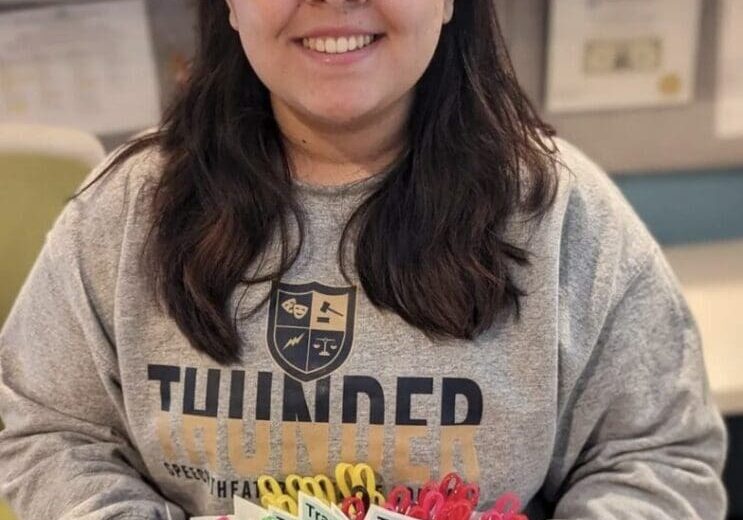 A girl holding a cake with candles on it.