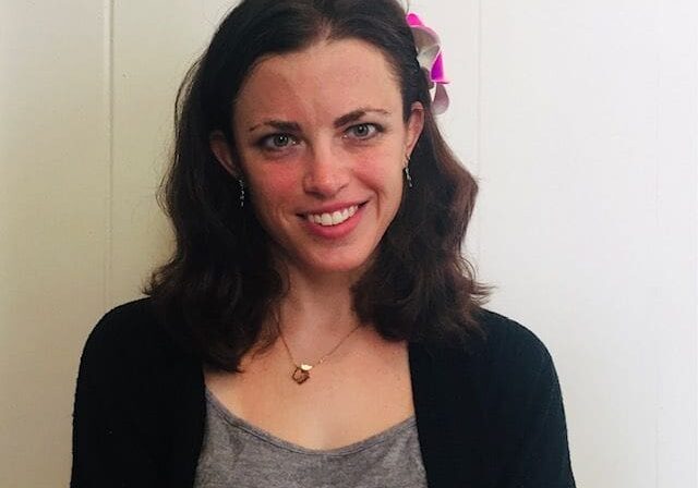 A woman with dark hair wearing a black sweater.