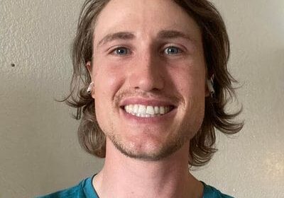 A man with long hair and a blue shirt.