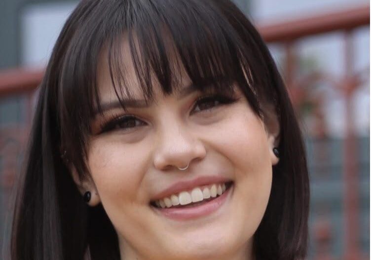 A woman with bangs smiles for the camera.