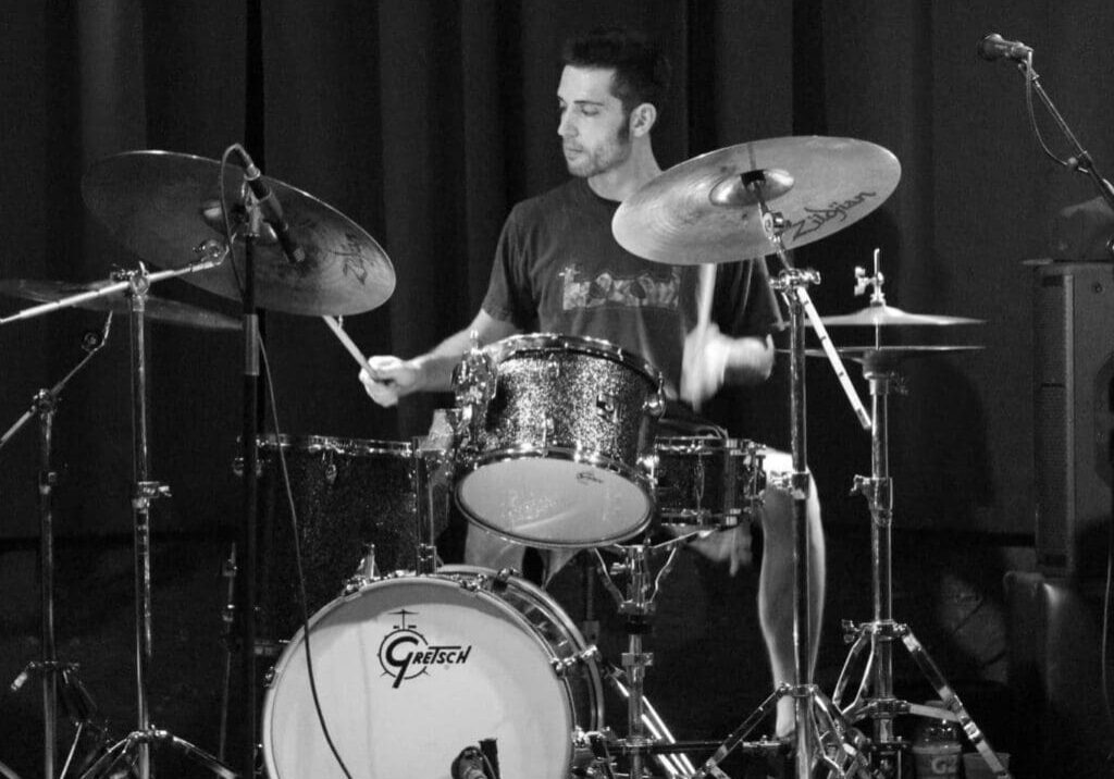 A man playing drums in front of a microphone.