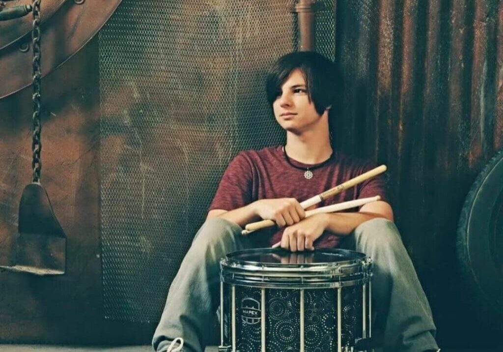 A man sitting on top of a drum.