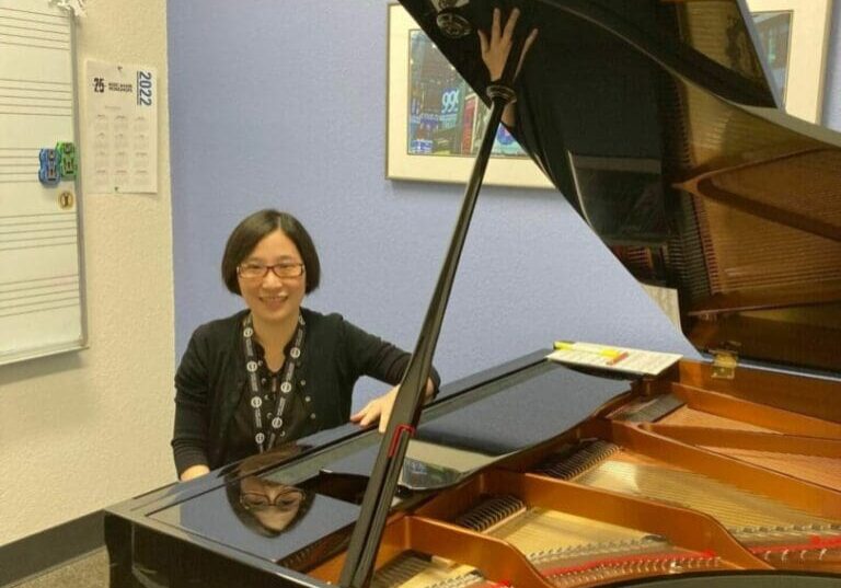 A woman sitting at the piano in an office.